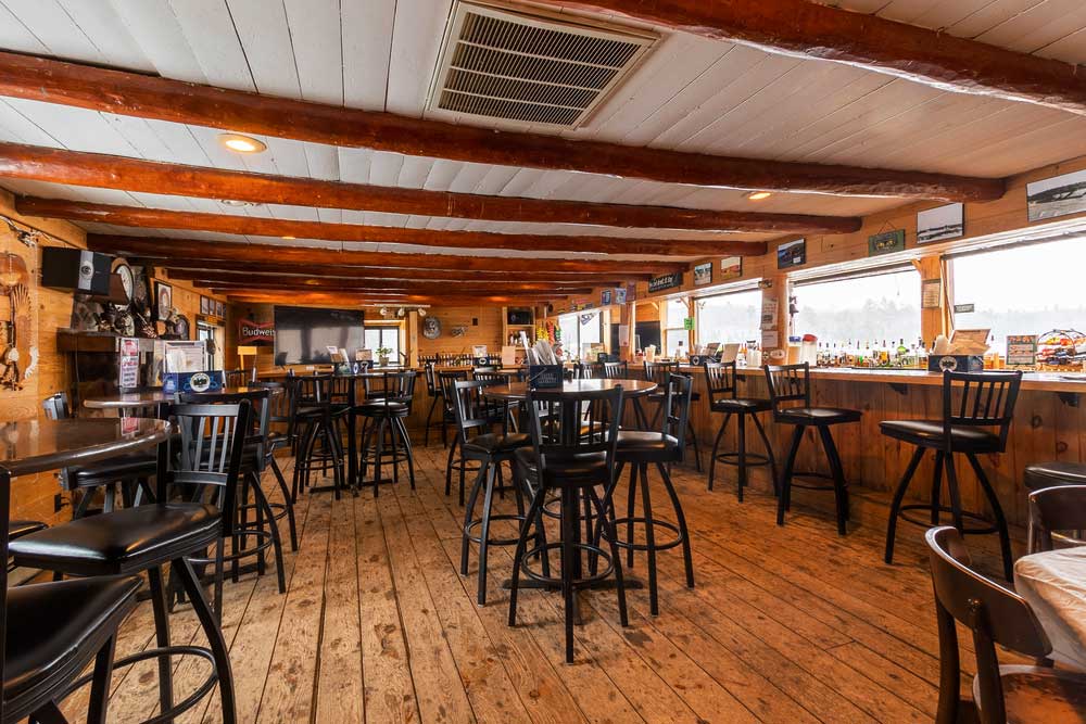 Flying Eagle restaurant with wooden beams, tables, and lake-facing windows